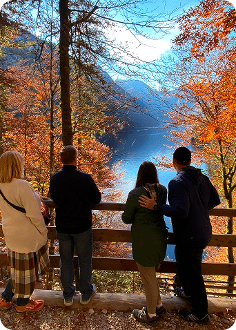Kleine Gruppe blickt im Herbst auf See und Berge bei einem Ausflug im Salzkammergut.