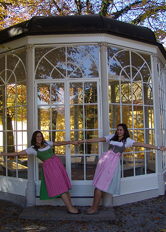 Frau im Dirndl posiert am berühmten Pavillon aus „The Sound of Music“ im Schlosspark von Salzburg.